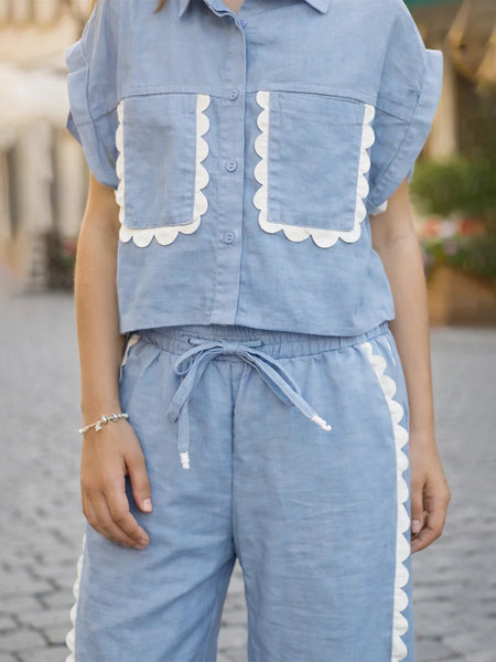 Person wearing a blue outfit with white trim on a blurred background