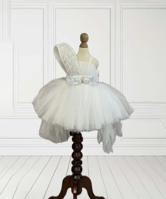 It’s a baby birthday party frock that comes with a back zip closure and a fabric belt to be tied at the back. It features a cute bow on the waist that adds grace to the look.