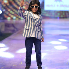 A boy wearing a striped blazer and sunglasses.