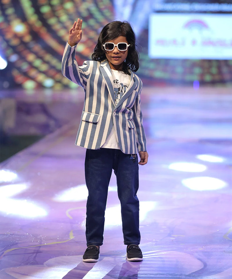 A boy wearing a striped blazer and sunglasses.