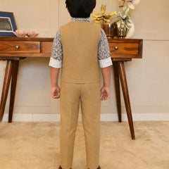 Person wearing a beige vest and pants set in a room with wooden furniture and decorative items.