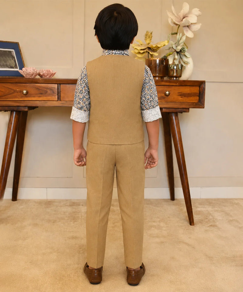 Person wearing a beige vest and pants set in a room with wooden furniture and decorative items.