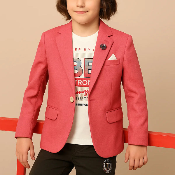Child wearing a red blazer over a white shirt with text, standing against a beige background.