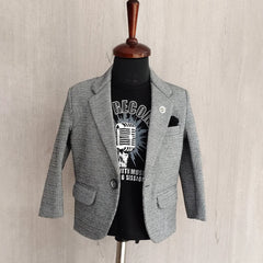 Gray blazer over a black t-shirt with graphic design on a mannequin against a beige wall.