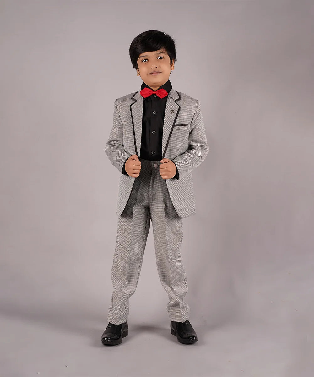 It's a light grey Colored checked coat suit set. It really helps you to leave a majestic impression. It comes with a checked coat, matching checked pants, black shirt, a broach and a red bow. 