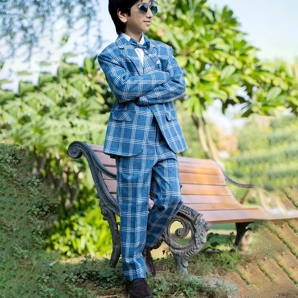 A classic blue checked suit set that comes with a white full-sleeve shirt, checked coat, matching pants and bow. It features one-button fastening, a broach-on lapel collar and pockets on both sides.