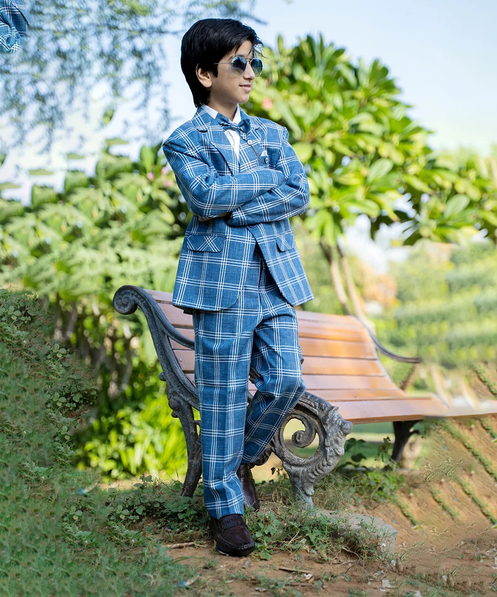 A classic blue checked suit set that comes with a white full-sleeve shirt, checked coat, matching pants and bow. It features one-button fastening, a broach-on lapel collar and pockets on both sides.