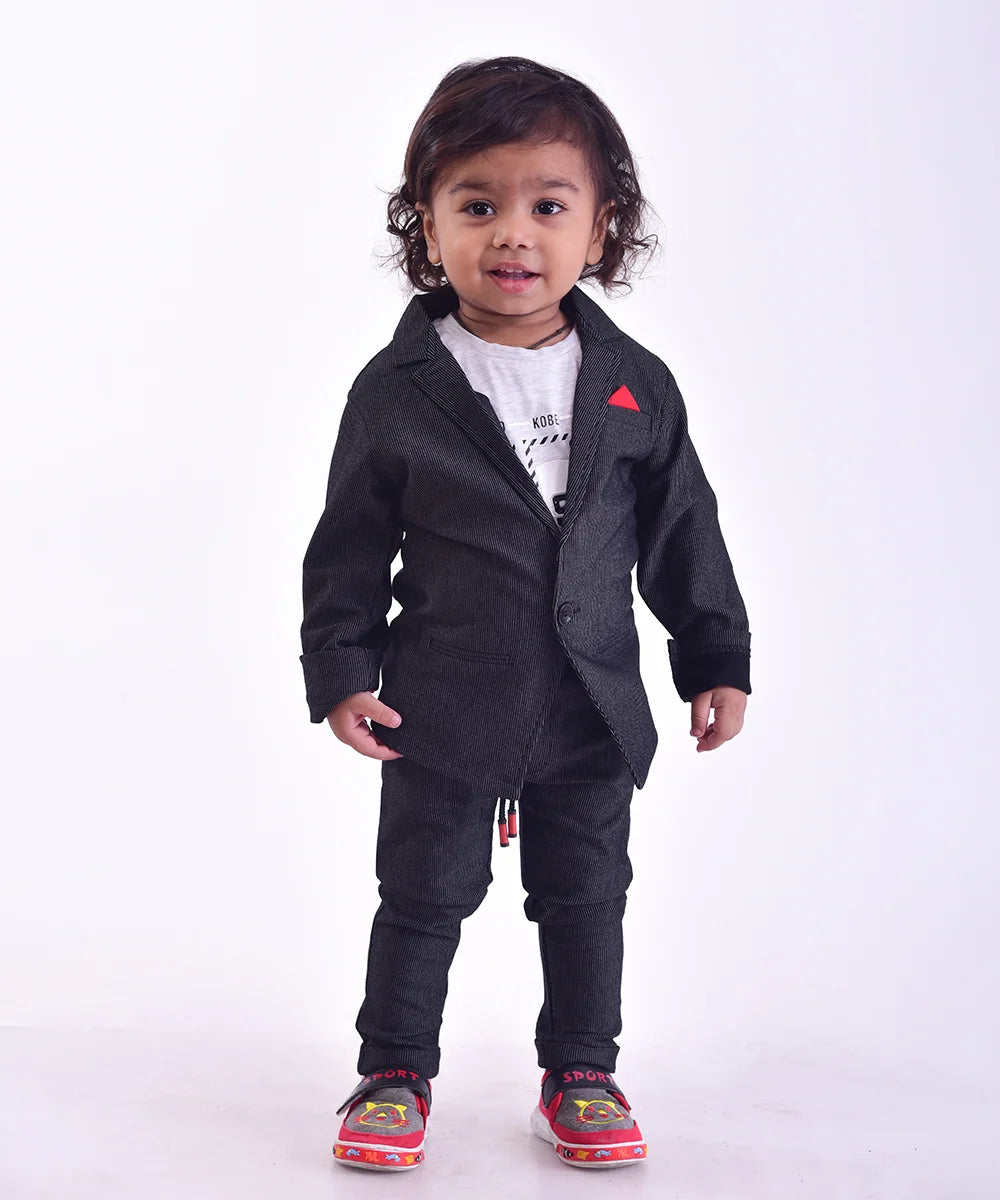 This black Colored boy's wedding outfit comes with trousers, a blazer a white round neck and a half-sleeved t-shirt