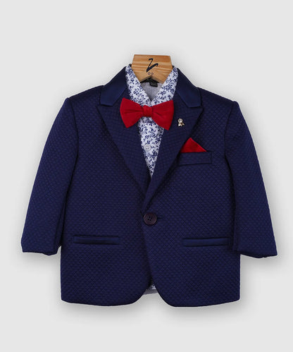 The coat is rendered in navy blue and paired up with a printed shirt, a red bow, a cute broach, a pocket square and matching tailored pants. It is created from a self-textured terry rayon fabric making it a timeless boys' party wear suit. 