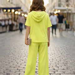 Person wearing a bright yellow outfit walking on a street.