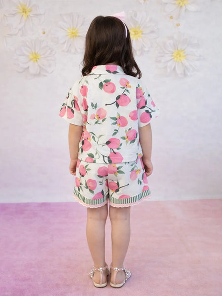 Child wearing a floral outfit with a pink background