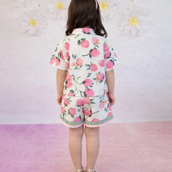 Child wearing a floral outfit with a pink background