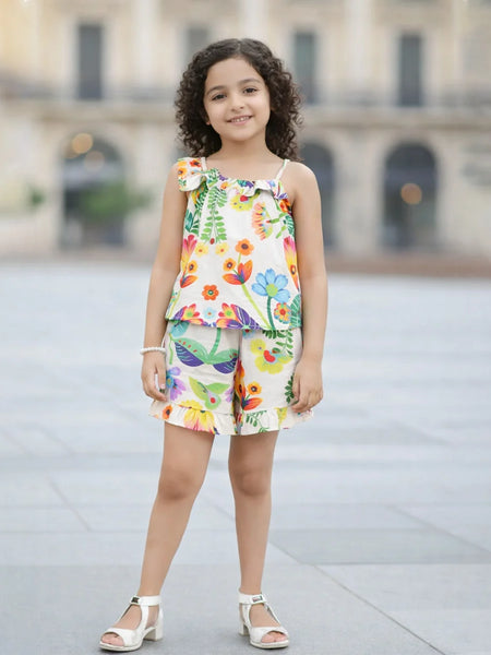 Young girl wearing a colorful floral top and shorts set on a blurred background
