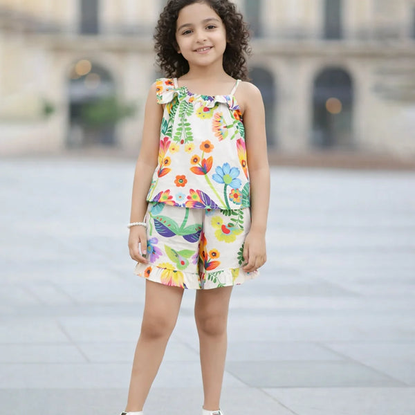Young girl wearing a colorful floral top and shorts set on a blurred background