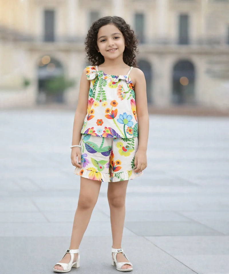 Young girl wearing a colorful floral top and shorts set on a blurred background