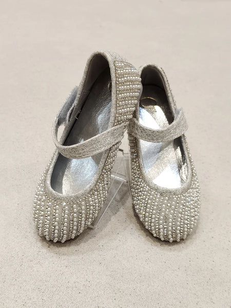 Pair of silver beaded shoes on a beige background