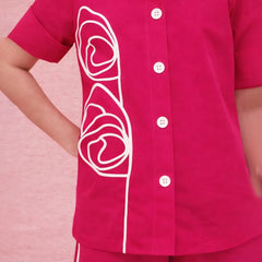 Pink shirt with white floral design on a pink background