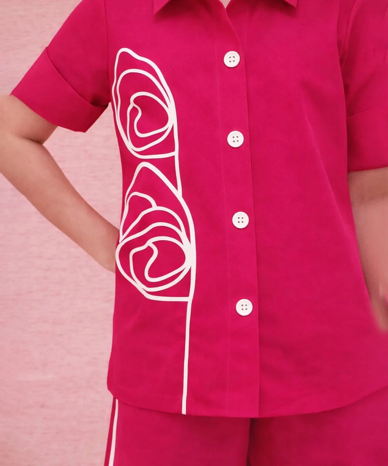 Pink shirt with white floral design on a pink background