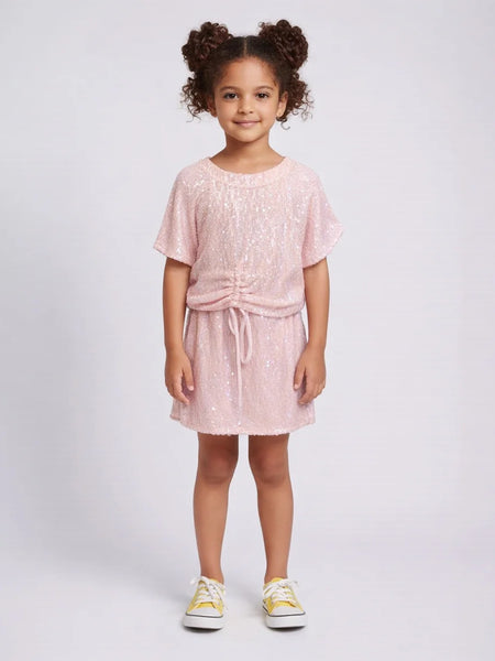 Young girl wearing a pink dress with a white background