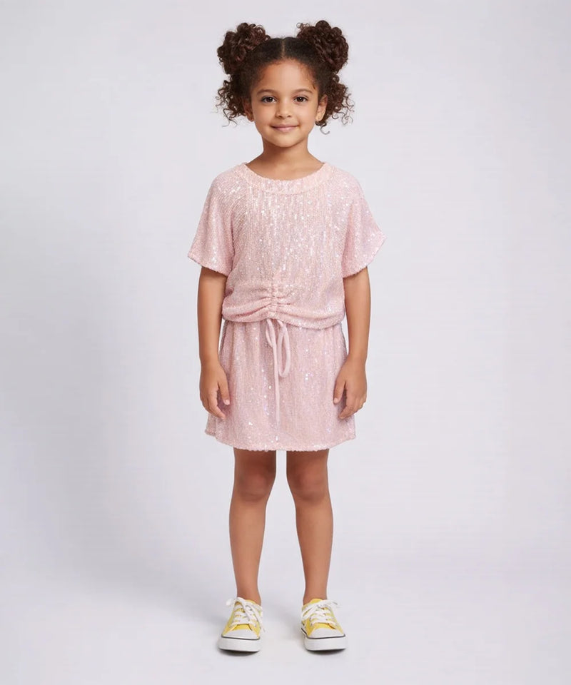 Young girl wearing a pink dress with a white background