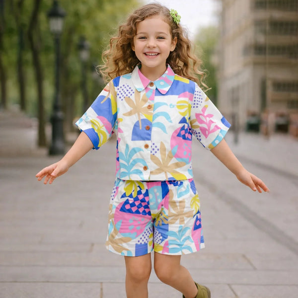 Young girl in a colorful outfit standing on a city street.