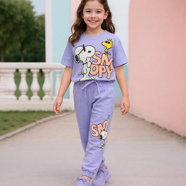Young girl wearing a purple Snoopy-themed outfit in an outdoor setting.