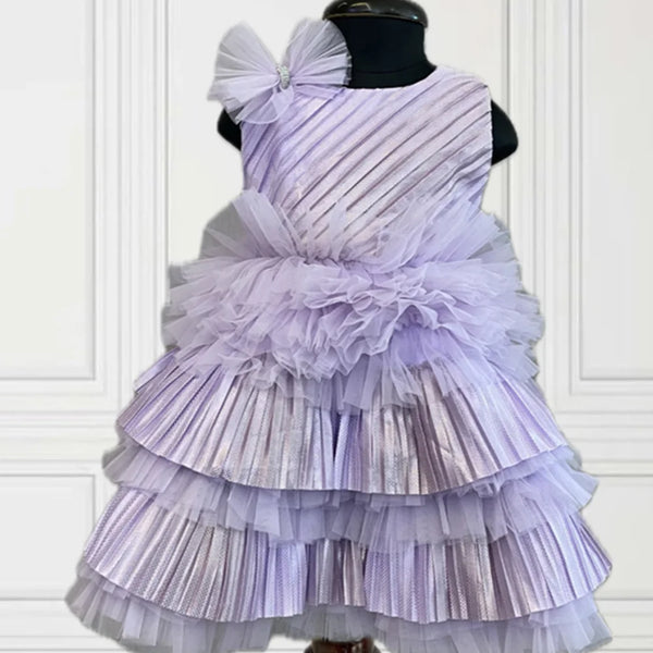  It’s a purple coloured pretty frock with lots of frills and pleated detailing. It features a cute bow detailing on the dress and a back zip closure. 