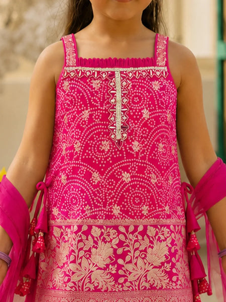 A close-up of a child wearing a bright pink sleeveless embroidered dress with beige floral and geometric patterns, paired with matching pink arm wraps.