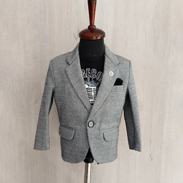 Gray blazer on a mannequin against a light wooden background