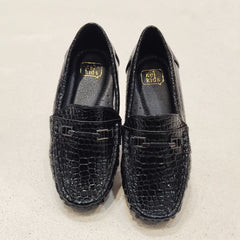 Pair of black loafers with a textured pattern on a light gray background
