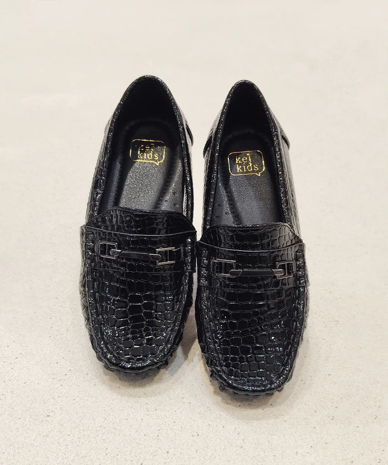 Pair of black loafers with a textured pattern on a light gray background