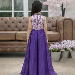 Woman wearing a purple dress with floral top in a living room setting