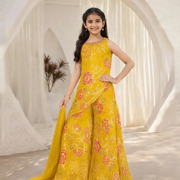 Young girl in a yellow floral dress standing in a bright, minimalistic setting.