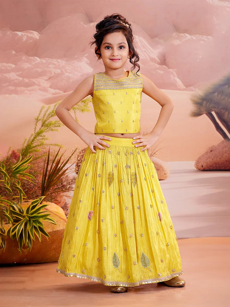 girls wearing yellow embroider lehenga choli in smiley face.
