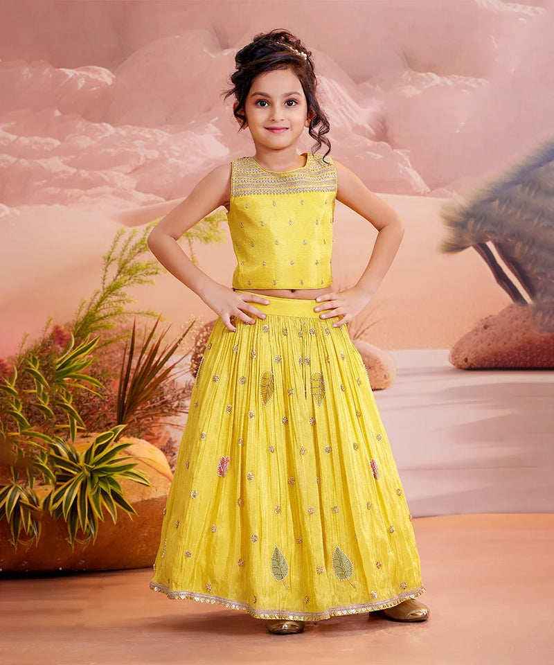 girls wearing yellow embroider lehenga choli in smiley face.