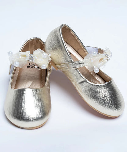 It's a golden-coloured party sandal for girls that comes with a bow and pearl detailing.