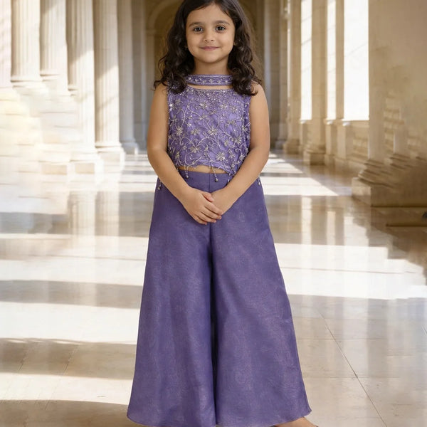 Young girl in a purple outfit standing in a sunlit hallway with columns.
