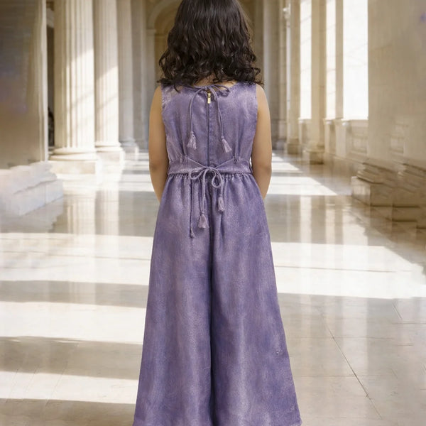 Woman in a purple dress standing in a grand hallway with high ceilings and large windows.