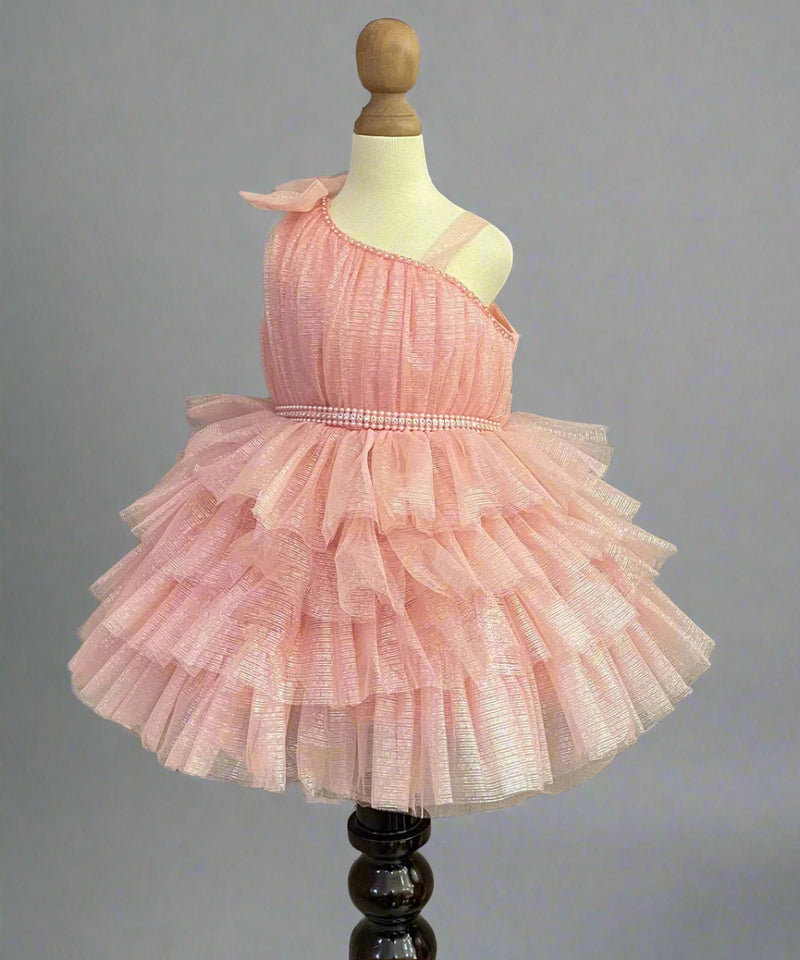 It's a peach Colored frock that features a cute bow on the shoulder and pearl belt attached on the waist.