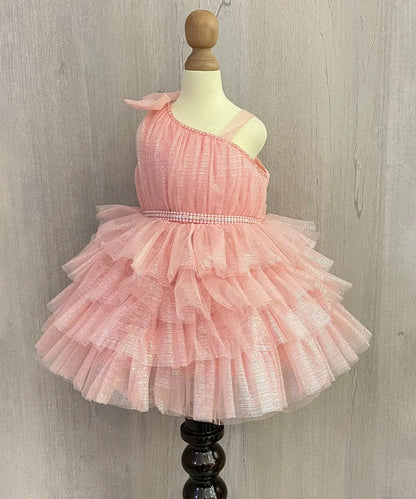 It's a peach Colored frock that features a cute bow on the shoulder and pearl belt attached on the waist.