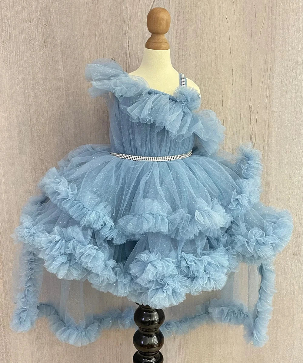 Powder blue Colored dress that comes with an attached belt, ruffle work and detachable cape.