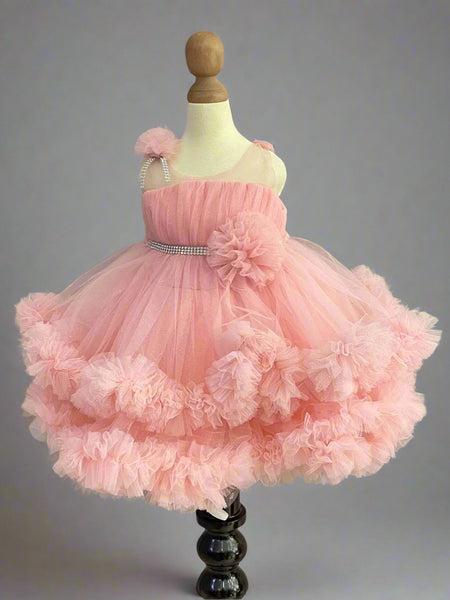 Pink Colored birthday wear frock that comes with a fancy belt attached on the waist and a beautiful floral detailing. 