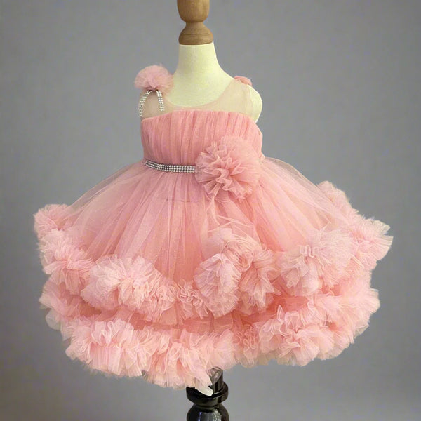 Pink Colored birthday wear frock that comes with a fancy belt attached on the waist and a beautiful floral detailing. 
