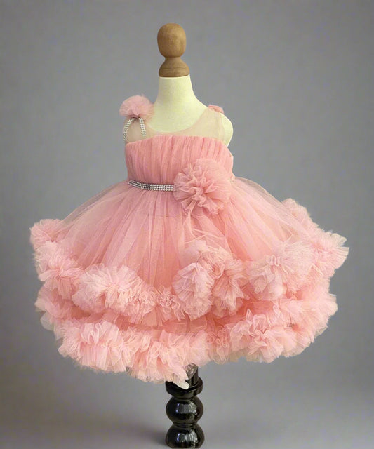 Pink Colored birthday wear frock that comes with a fancy belt attached on the waist and a beautiful floral detailing. 