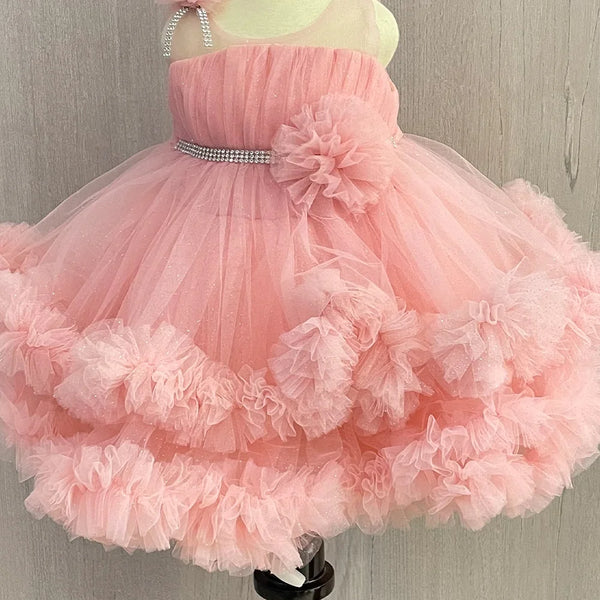 Pink Colored birthday wear frock that comes with a fancy belt attached on the waist and a beautiful floral detailing. 