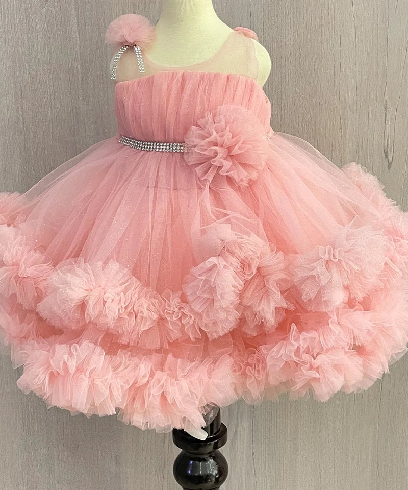 Pink Colored birthday wear frock that comes with a fancy belt attached on the waist and a beautiful floral detailing. 