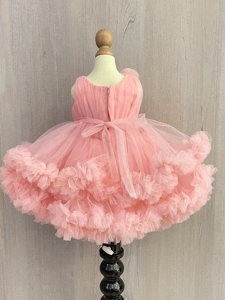 Pink Colored birthday wear frock that comes with a fancy belt attached on the waist and a beautiful floral detailing. 