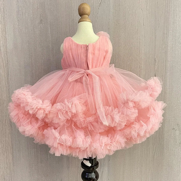 Pink Colored birthday wear frock that comes with a fancy belt attached on the waist and a beautiful floral detailing. 