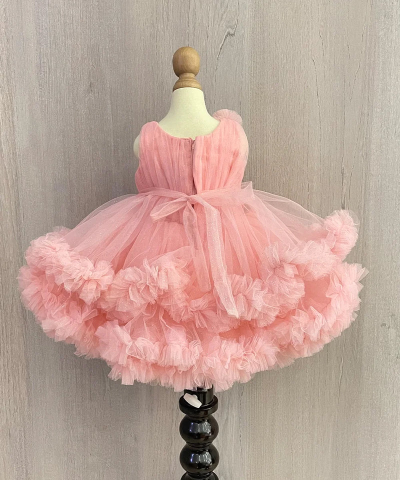Pink Colored birthday wear frock that comes with a fancy belt attached on the waist and a beautiful floral detailing. 