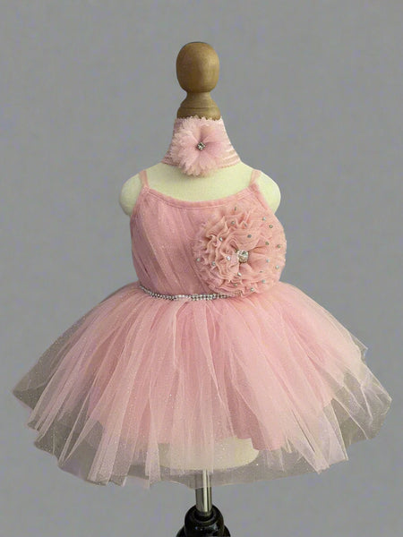  It’s a stylish peach Colored frock that comes with a back zip closure. It is paired up with matching shoes and hair band.